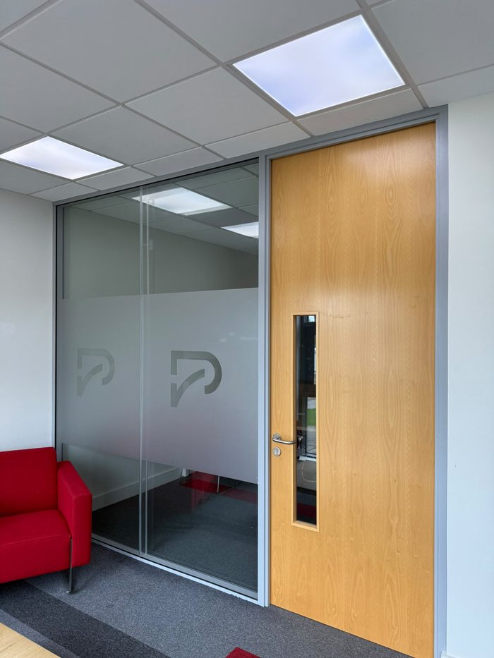 Frosted vinyl logo graphic on an internal office glass door